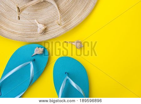 Women's straw hat blue slippers sea shells nectarine on yellow background beach vacation seaside fashion top view copyspace