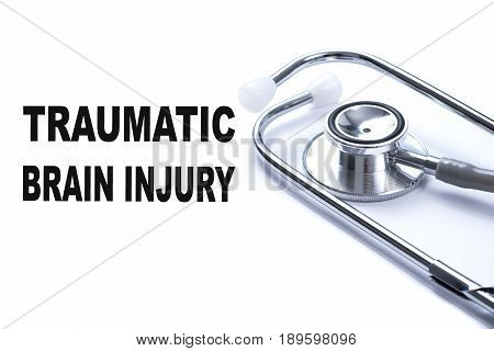 Page with TRAUMATIC BRAIN INJURY on the table with stethoscope medical concept.