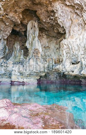 Calm turquoise colored water in coral rock pool in limestone cave at Avaiki on coast of Niue.