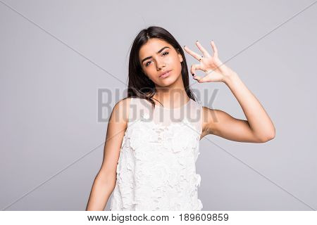 Young Girl Shows Okay Gesture, Isolated On Grey Background
