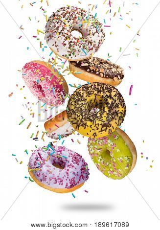 Tasty doughnuts in motion falling on white background, close-up.
