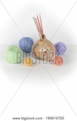 Colored yarn on a white background. Skeins of wool yarn for knitting. Balls of wool of different colours for handmade knitting on a wooden background with copy space for ad