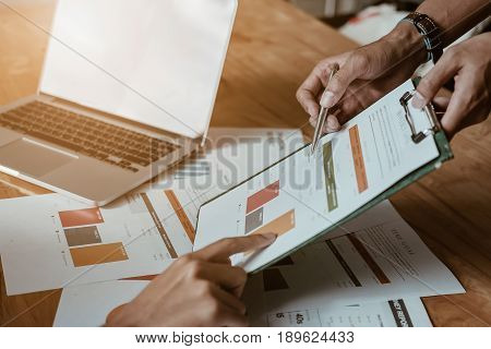 Businessman Using Pen Pointing Graph Chart With Pathner For Analyze Plans In This Mounth.