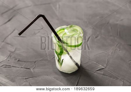 glass with fresh cocktail made of ice on concrete table. concept
