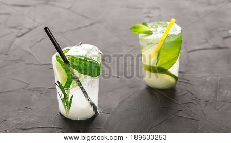 two glasses with fresh cocktail made of ice on concrete table. concept