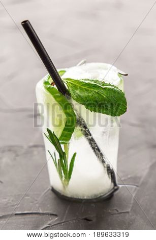 glass with fresh cocktail made of ice on concrete table. concept. vertical