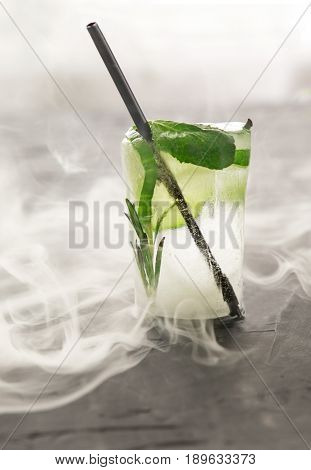 glass with fresh cocktail made of ice on concrete table. concept. vertical