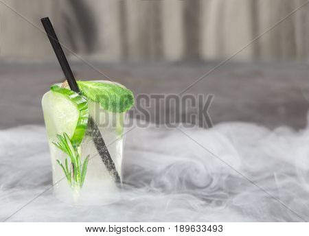 glass with fresh cocktail made of ice on concrete table. concept