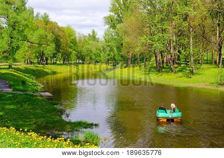 VITEBSK BELARUS - MAY 21 2017: Unknown people ride on catamaran on River Vitba in park of culture and rest named after Frunze on sunny day in May Vitebsk Belarus