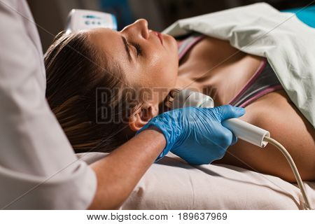 Young attractive woman on reception at the beautician's office. Procedure electric myostimulation. Hardware cosmetology. Equipment for Cosmetology