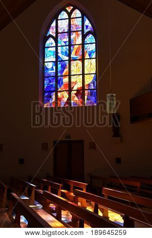 Modern Stained Glass Windows Reflecting Colors On Church Pews