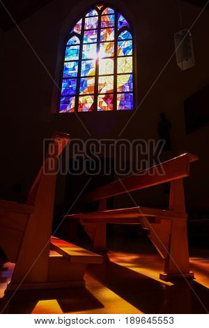 Modern Stained Glass Windows Reflecting Colors On Church Pews