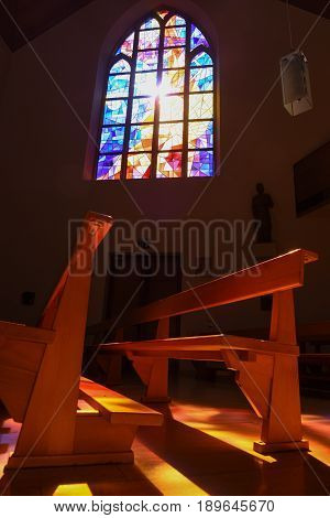 Modern Stained Glass Windows Reflecting Colors On Church Pews