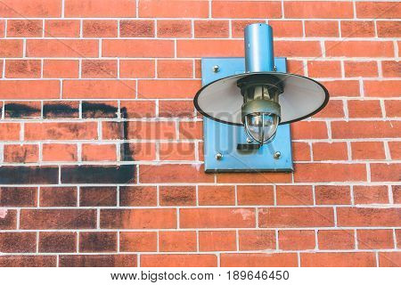 Metall lamp fixed on a brick wall.