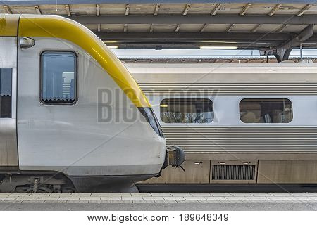 Two stationary trains in a typical urban railway station that could be in any modern city in the world.
