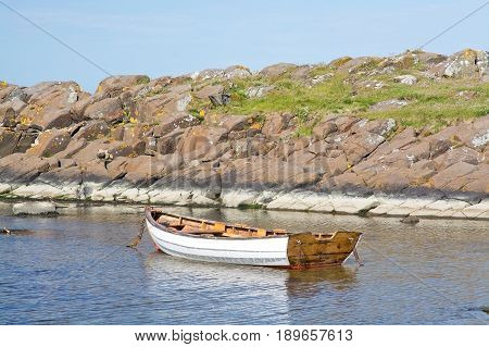 Boat moored in a tranquil bay in Halland Sweden in June.