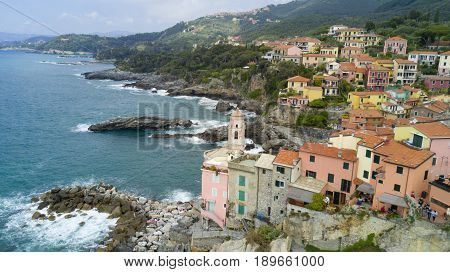 Aerial video shooting with drone on Tellaro, famous Ligurian village near the Cinqueterre, small colored houses built on the cliff by the sea