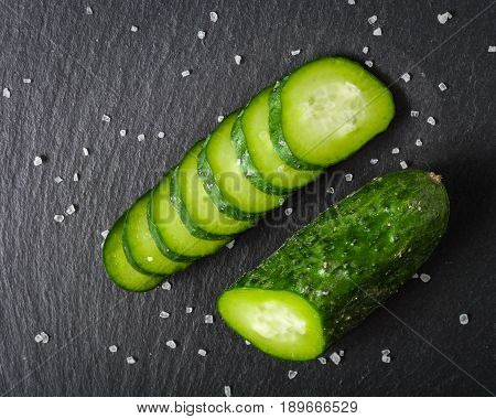 Fresh Green Sliced Cucumber On A Black Stone Background.