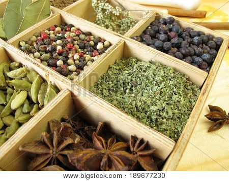 Wooden box with pepper, marjoram, coriander and other spices