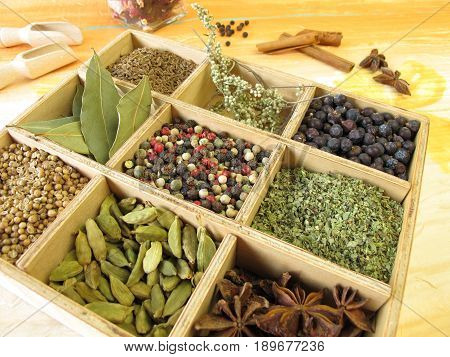 Wooden box with pepper, marjoram, coriander and other spices