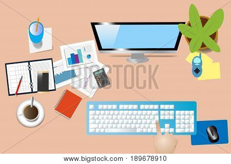 Top view of office desk with supplies computer monitor and keyboard. Hand is touching computer keyboard.