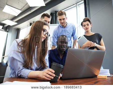 Teamwork concept.Young creative coworkers working with new startup project in modern office.Group of people analyze data on desktop computer.