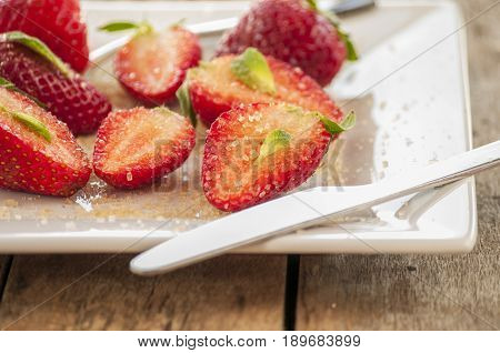 strawberries cut with sugar and mint close up