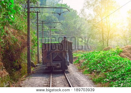 Worker stands on the tail of empty freight train. Yuejin. Jiayang Mining Region. Sichuan province. China