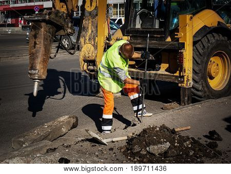 Road worker breaks the borders on the sidewalk. Working stonemasons repair the sidewalk install curbs before asphalting for road