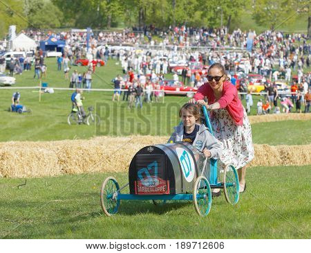 STOCKHOLM SWEDEN - MAY 21 2017: Mother push her son up a hill in a home made soapbox car in the race Gardesloppet at Djurgarden Stockholm Sweden. May 21 2017