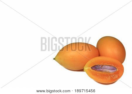 Closed up fresh ripe whole Marian Plum fruit and cut in half with seed, isolated on white background with free space for text and design