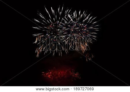 Beautiful colorful fireworks on the water surface with a clean black background. Fun festival and contest of Firefighters.