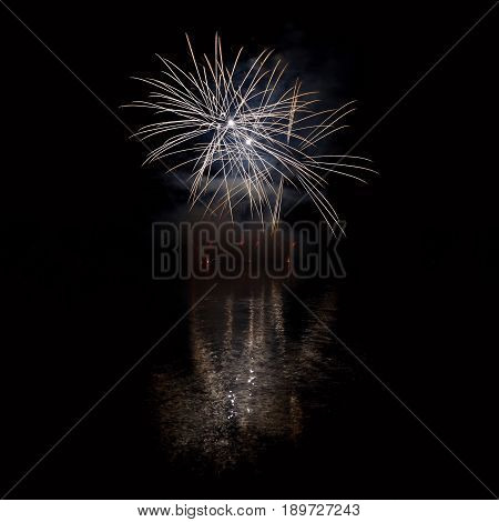 Beautiful colorful fireworks on the water surface with a clean black background. Fun festival and contest of Firefighters.