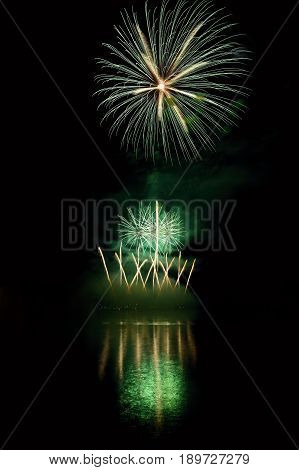 Beautiful colorful fireworks on the water surface with a clean black background. Fun festival and contest of Firefighters.