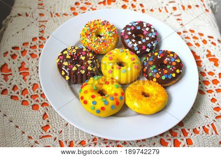 Yellow and brown donuts on a white plate