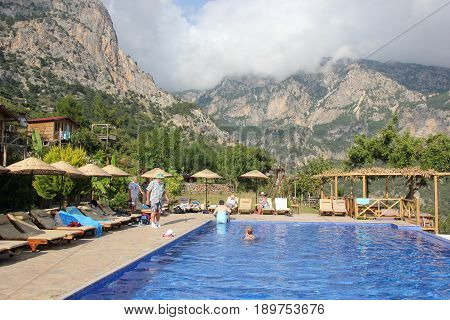 30TH MAY 2017, KABAK, TURKEY : English tourists having a swim and cooling off in an infinity pool at the olive garden in Kabak in Turkey, 30th may 2017