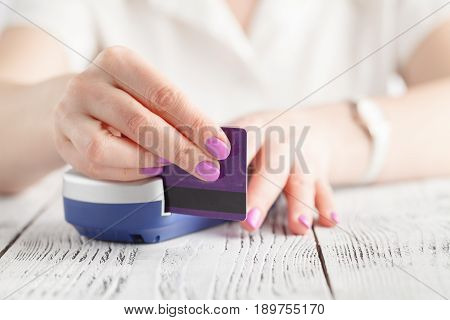 Hand Swiping Debit Card On Pos Terminal