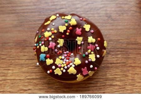 Single brown donut on a wood background
