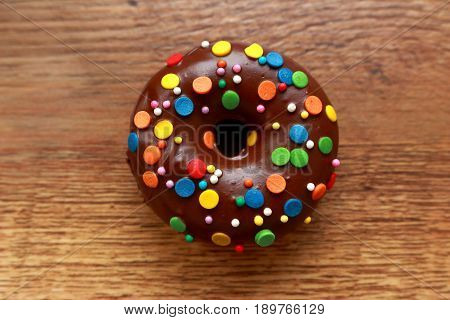 Single brown donut on a wood background