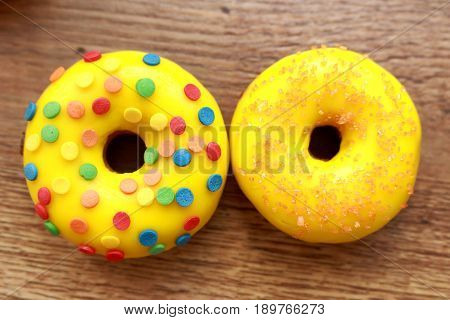 Two assorted donuts on a wood background