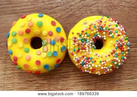Two assorted donuts on a wood background