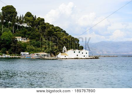 KANONI, GREECE - MAY 15: Tourists visit the old Greek Christian Orthodox church Vlacherna Monastery on May 15, 2017 in Kanoni, Corfu island in Greece.