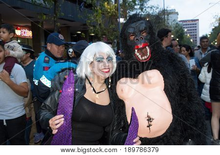 Quito, Ecuador - December 31, 2016: An unidentified couple dreessed in differents ways of clothes celebrating new years gathering in city streets.
