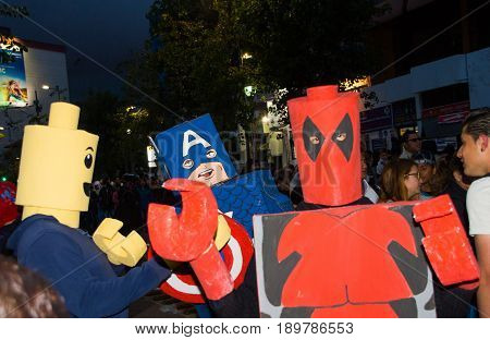 Quito, Ecuador - December 31, 2016: An unidentified group of people dreessed as deadpool, captain America, and lego man, celebrating new years gathering in city streets.