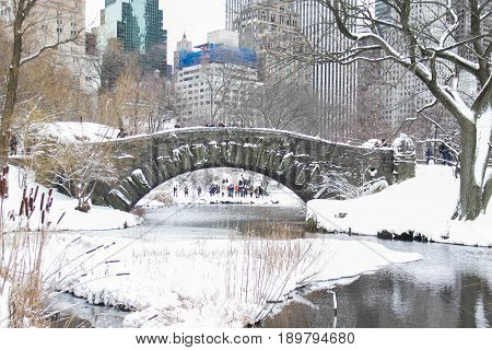 Gapstow bridge and snow at Central Park and buildings of Manhattan