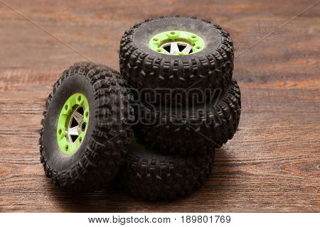 Wheels of Rc radio control car crawler model toy. Pile of spare parts for suv in repairshop workplace, top view