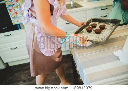 cupcakes are on the tray. Female hands holding dessert.Multi-colored cakes
