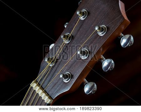 detail of Tuning head for acoustic guitar peg close up shot black background