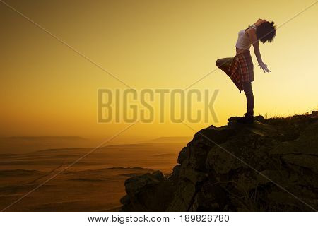 Young woman dancer on outdoor unrise background.