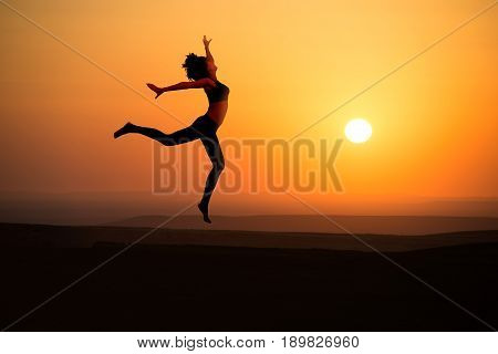 Young woman dancer on outdoor unrise background.